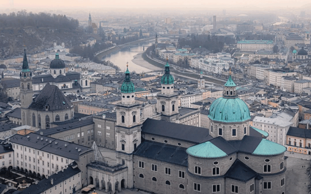 Winterliche Stadtansicht von Salzburg am Abend, beleuchtete Architektur und malerische Landschaft